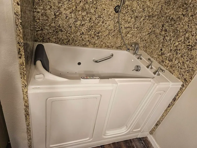 Step-in walk-in tub with hydrotherapy jets, chrome handheld and granite tub deck — built for safe, independent bathing